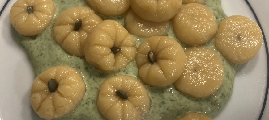 Ñoquis de calabaza con salsa de queso y espinacas.